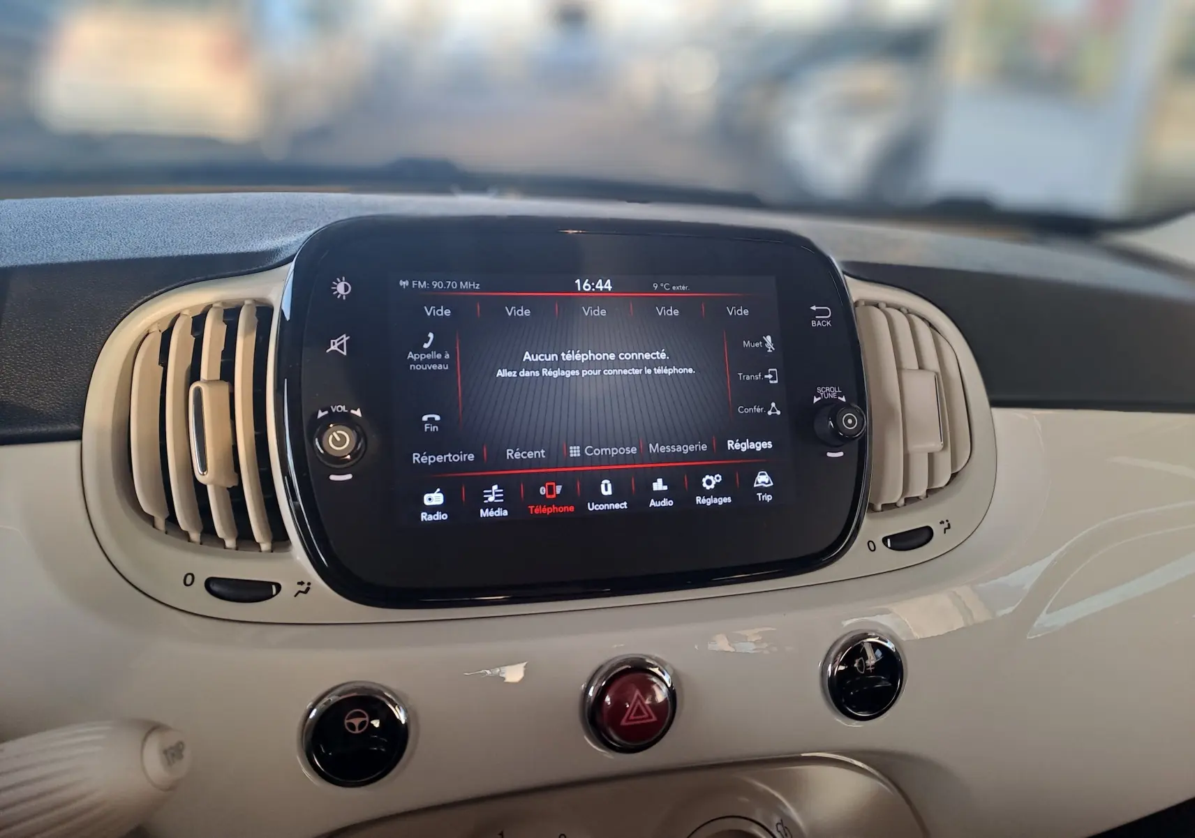 Tableau de bord blanc de la Fiat 500 2023 avec écran tactile central et commandes d'aération visibles en gros plan.