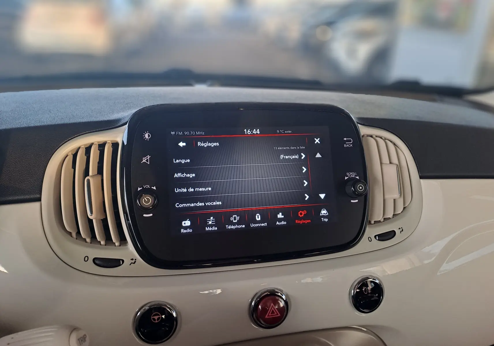 Écran tactile central du tableau de bord blanc de la Fiat 500 2023 affichant le menu réglages en français.