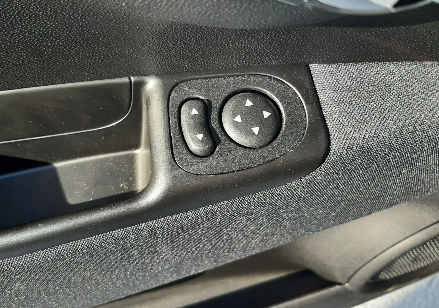 Gros plan sur les commandes de réglage des rétroviseurs sur la portière côté gauche d'une FIAT 500 blanche 2023.