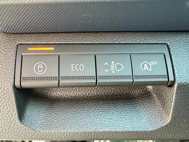 Boutons de commande du tableau de bord du Dacia Bigster blanc, avec mode ECO et arrêt auto du moteur visibles.