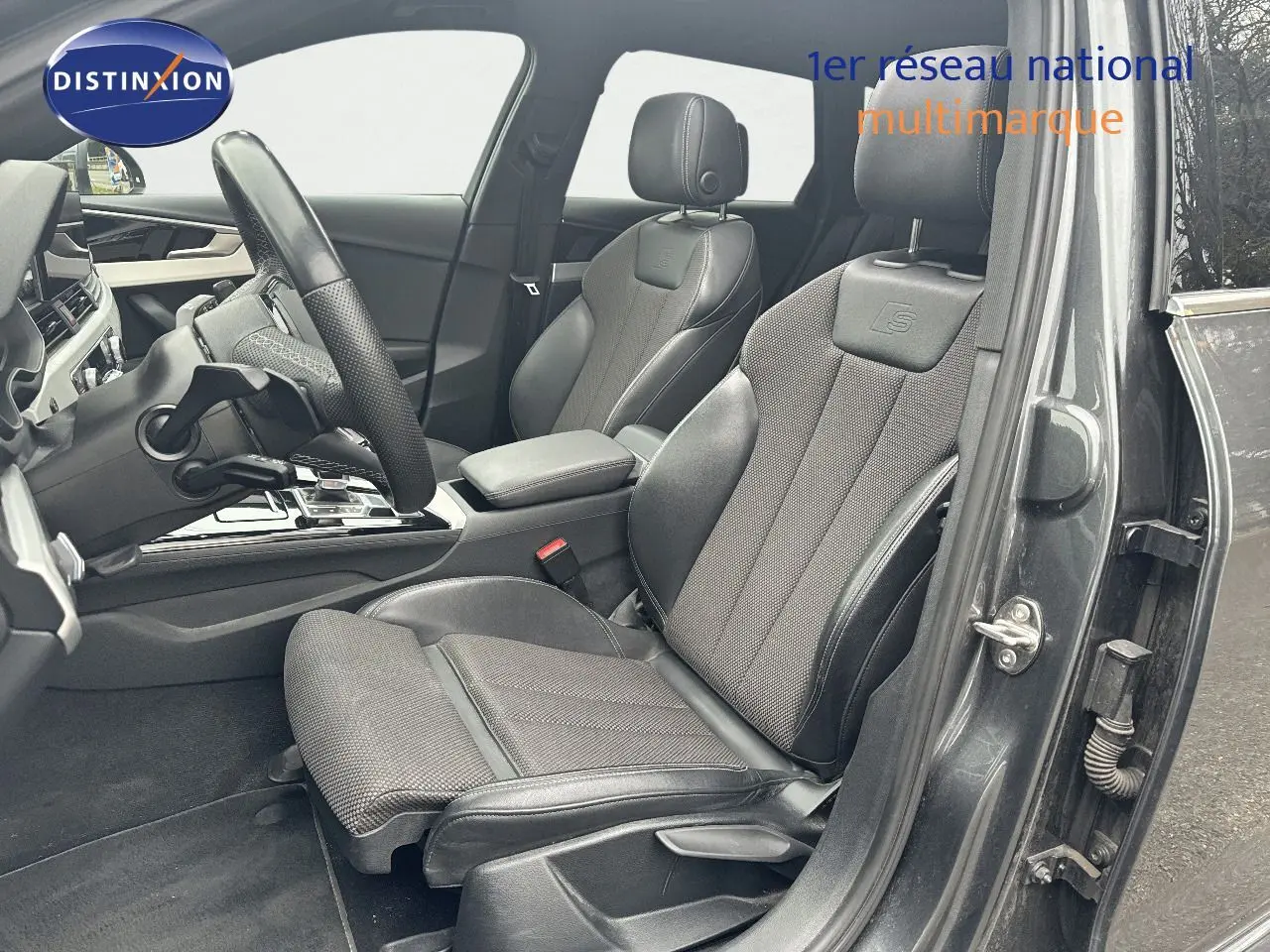 Vue intérieure côté conducteur de l'Audi A4 Avant gris Daytona, sièges sport S-Line en cuir et tissu noir.