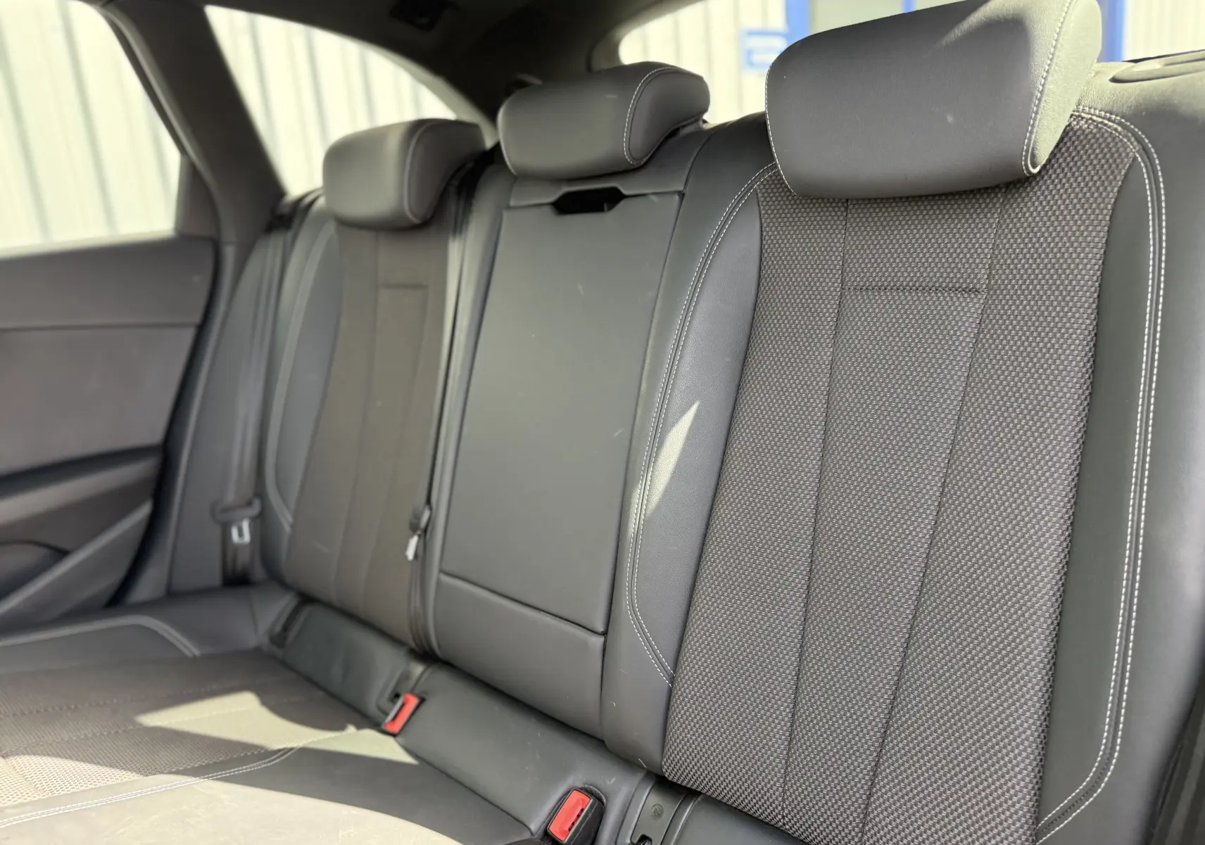 Vue rapprochée des sièges arrière en cuir noir avec surpiqûres blanches de l'Audi A4 Avant 35 TDI 2023.
