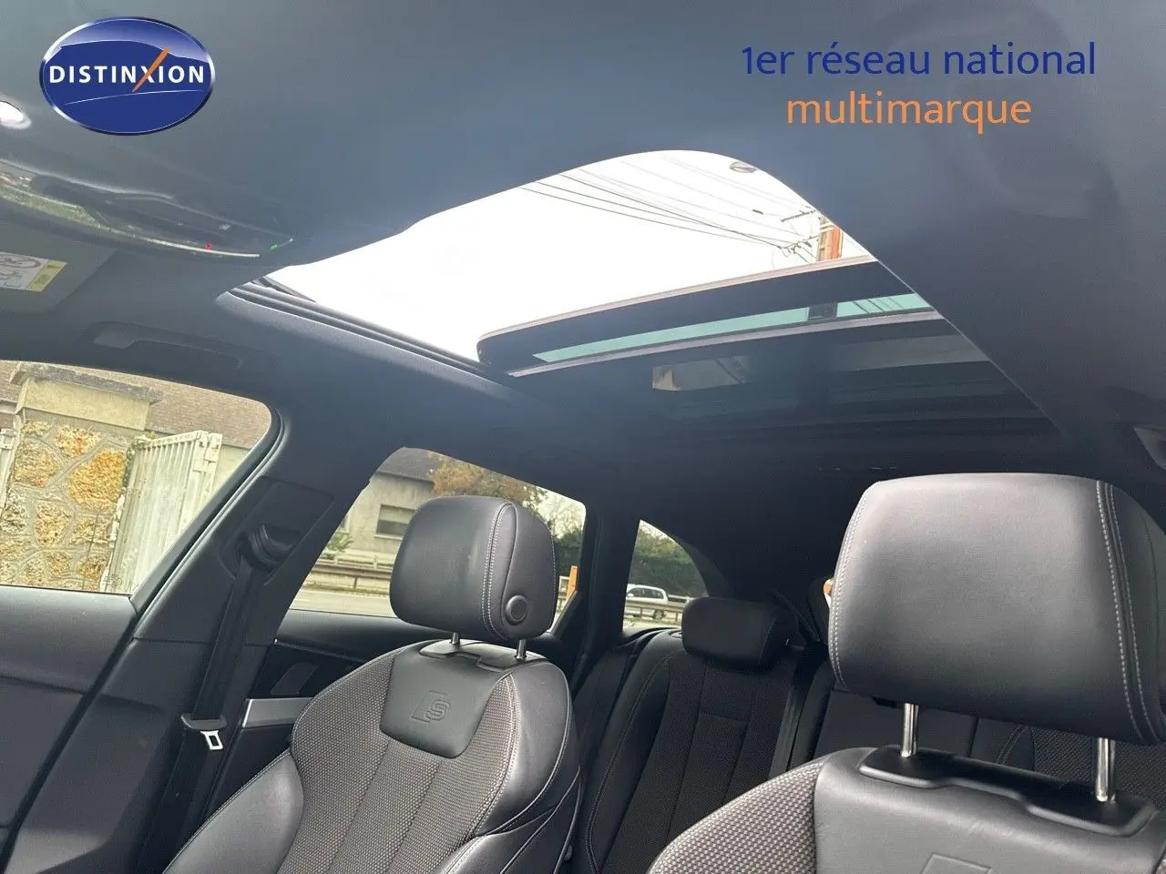 Vue intérieure de l'Audi A4 Avant 35 TDI S-Line 2023, sièges cuir noir avec logo S et toit ouvrant panoramique.