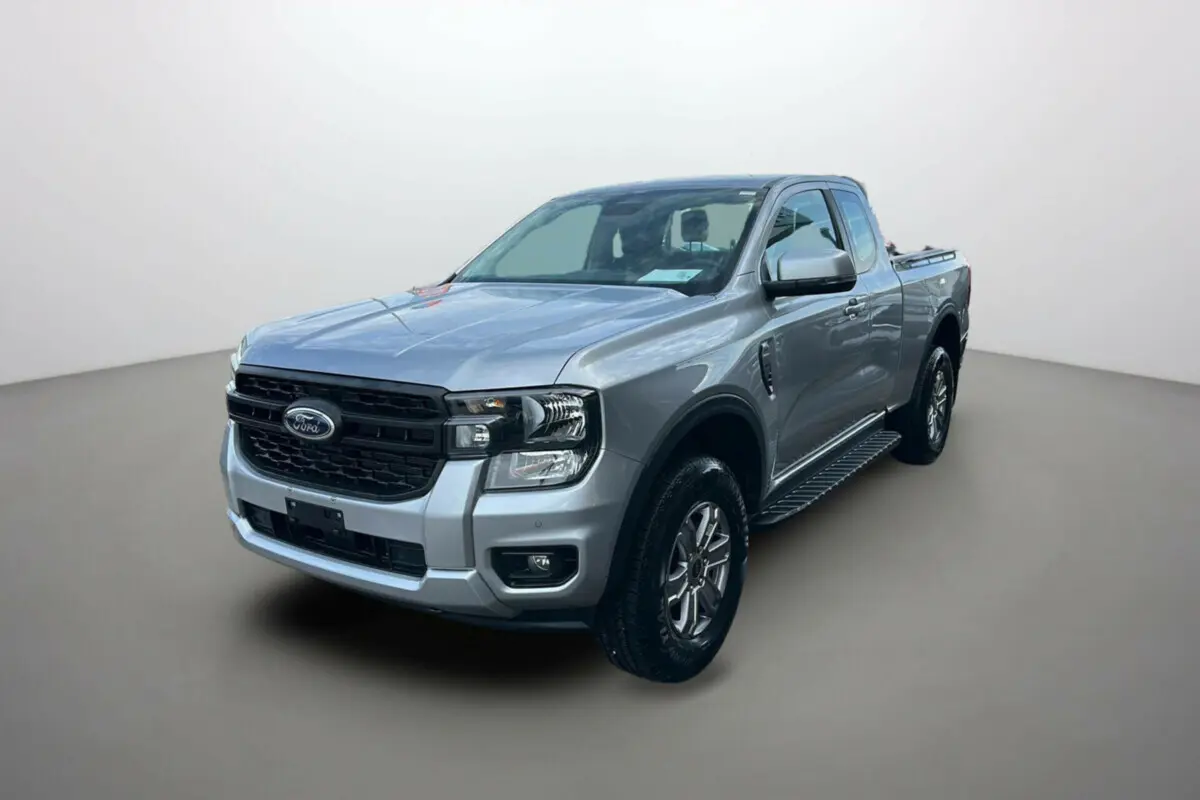 Vue 3/4 avant du Ford Ranger gris iconic avec marchepieds latéraux et calandre noire distinctive.