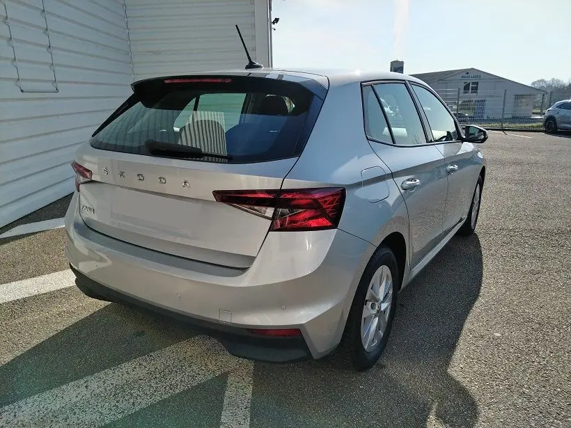 Vue 3/4 arrière droite d'une Skoda Fabia blanche 5 portes de 2023, avec feux arrière LED et antenne de toit.