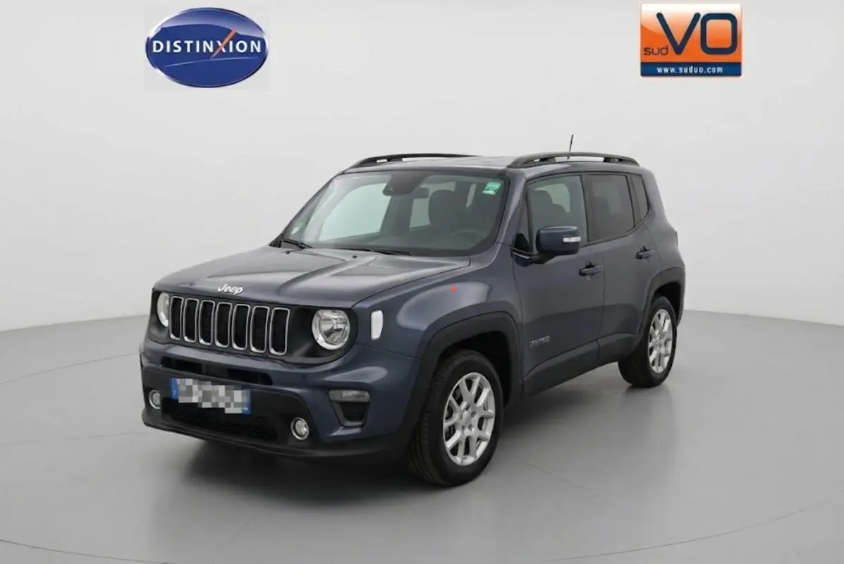 Jeep Renegade bleu en 3/4 avant droit, avec barres de toit et jantes alliage 17 pouces visibles.