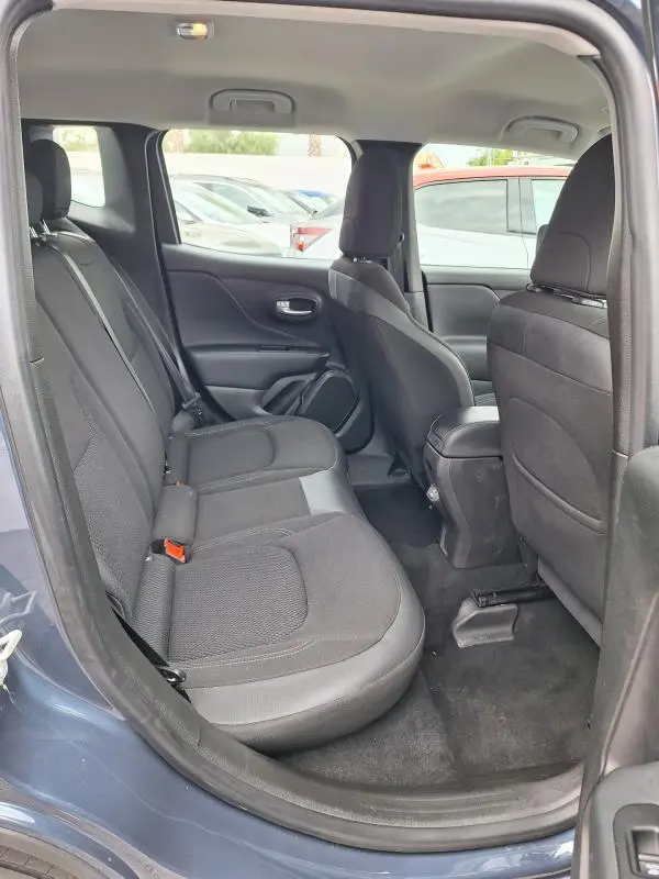 Vue intérieure côté gauche montrant les sièges arrière noirs du Jeep Renegade bleu 2024, avec accoudoir central et espace passagers.