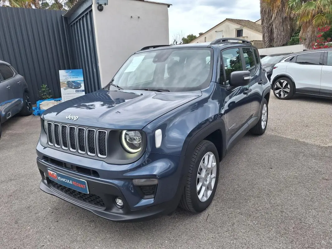 Jeep Renegade bleu en 3/4 avant droit, avec barres de toit et jantes alliage 17 pouces visibles.
