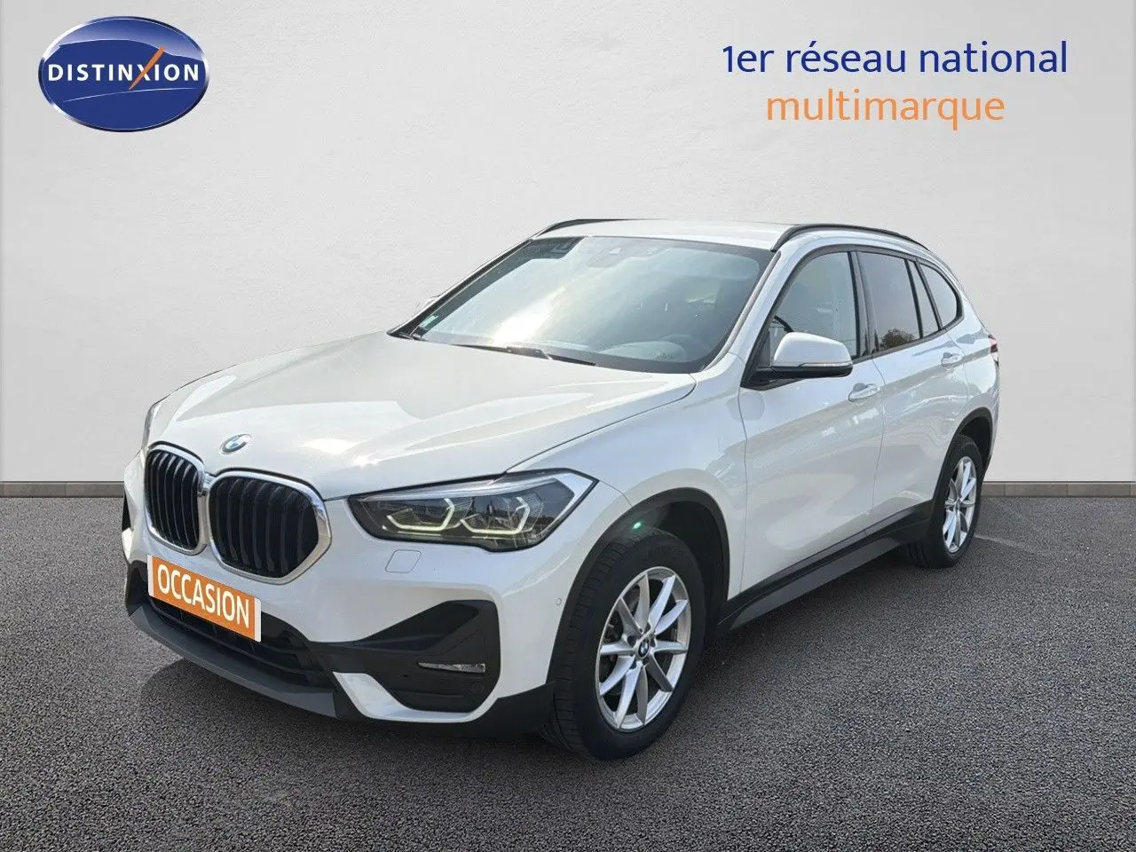 BMW X1 blanc en vue 3/4 avant droit, avec calandre noire et jantes alliage 17 pouces visibles.