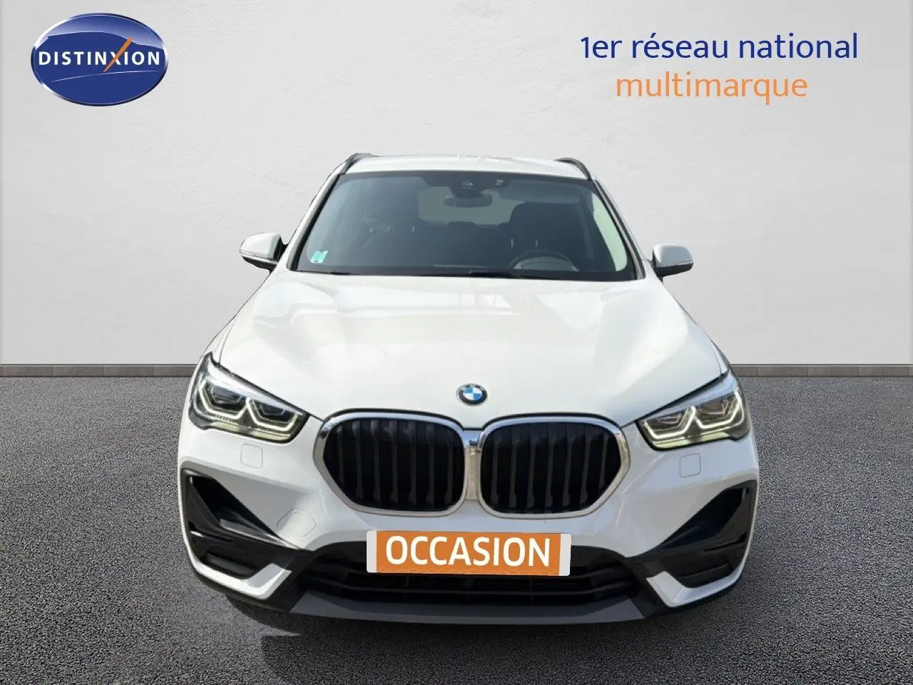 BMW X1 blanc vue de face mettant en valeur la calandre noire et les phares LED distinctifs.