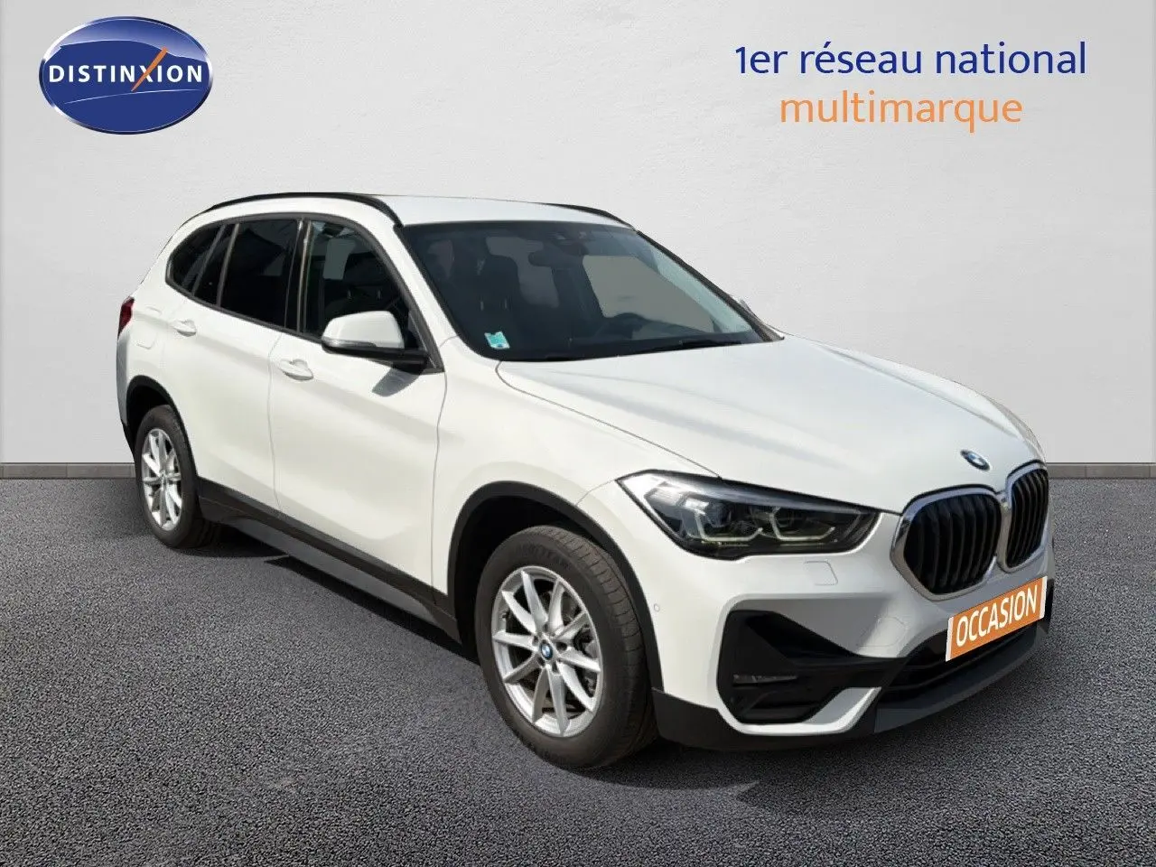 BMW X1 blanc en vue 3/4 avant droit, mettant en valeur sa calandre distinctive et ses jantes alliage.