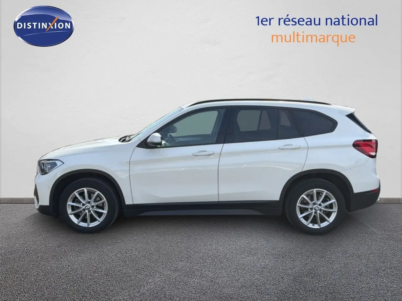 BMW X1 blanc vue de profil côté gauche, soulignant ses jantes alliage et sa silhouette compacte SUV.