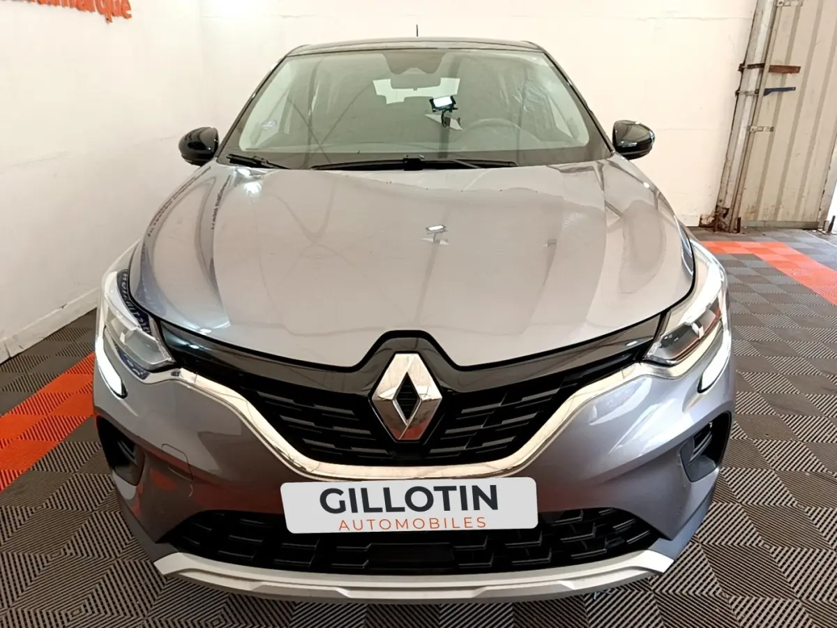 Vue frontale d’un Renault Captur Zen E-Tech hybride gris foncé avec calandre noire et feux LED allumés.