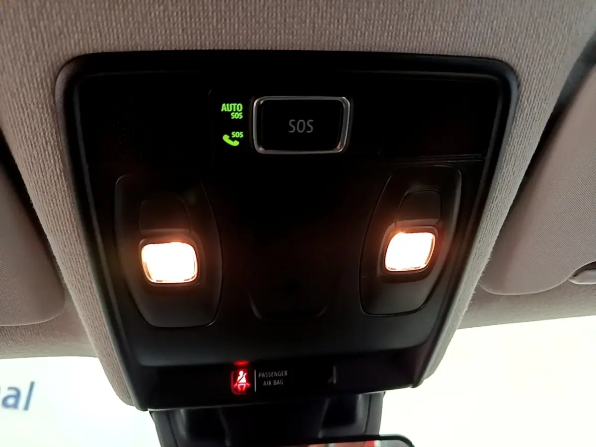 Gros plan sur la console de toit intérieure du Renault Captur gris foncé, avec éclairages et bouton SOS allumé.