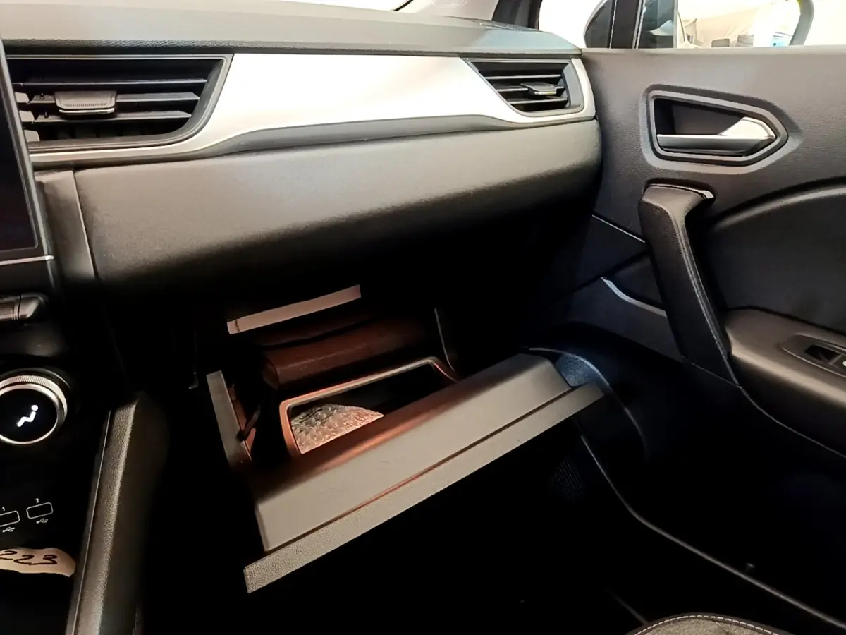 Intérieur du Renault Captur Zen E-Tech 2022, vue côté passager sur la boîte à gants ouverte et tableau de bord noir.