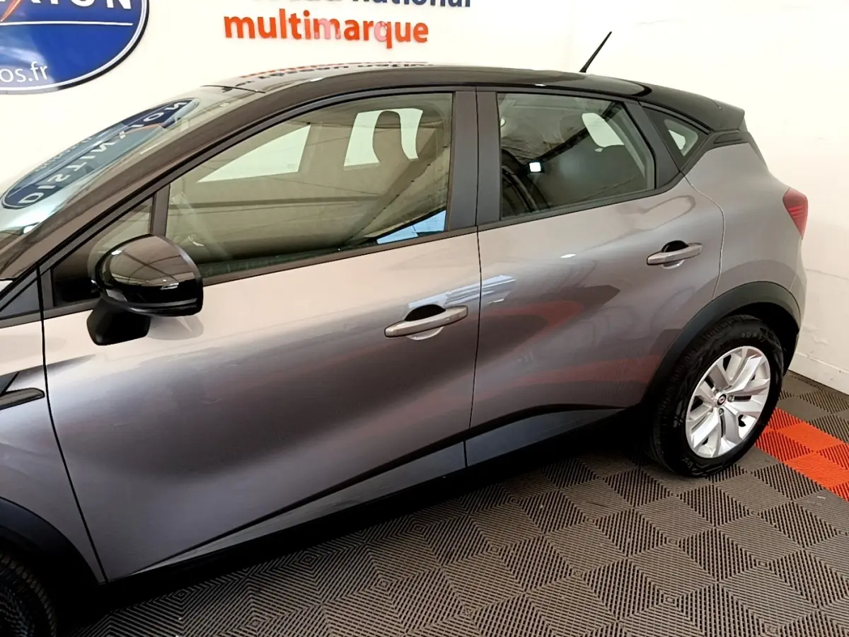 Profil côté gauche du Renault Captur Zen E-Tech hybride gris foncé 2022, avec rétroviseur noir brillant et jantes argentées.