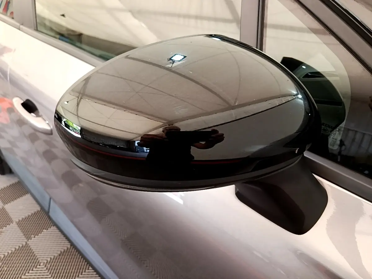 Gros plan sur le rétroviseur droit noir brillant du Renault Captur gris foncé, vue latérale côté passager.