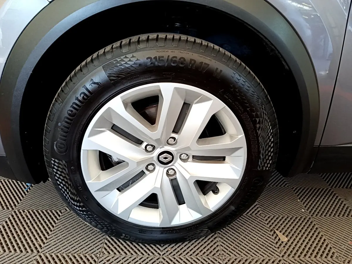 Gros plan sur la roue avant droite du Renault Captur gris foncé, mettant en valeur la jante alliage et le pneu Continental.