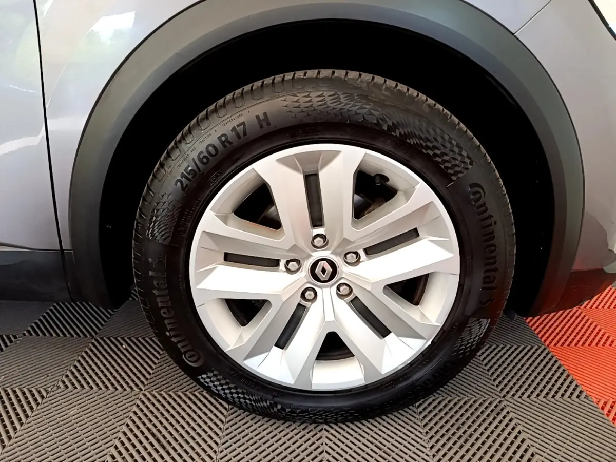 Gros plan sur la roue avant gauche du Renault Captur gris foncé, mettant en valeur la jante alliage et le pneu Continental.