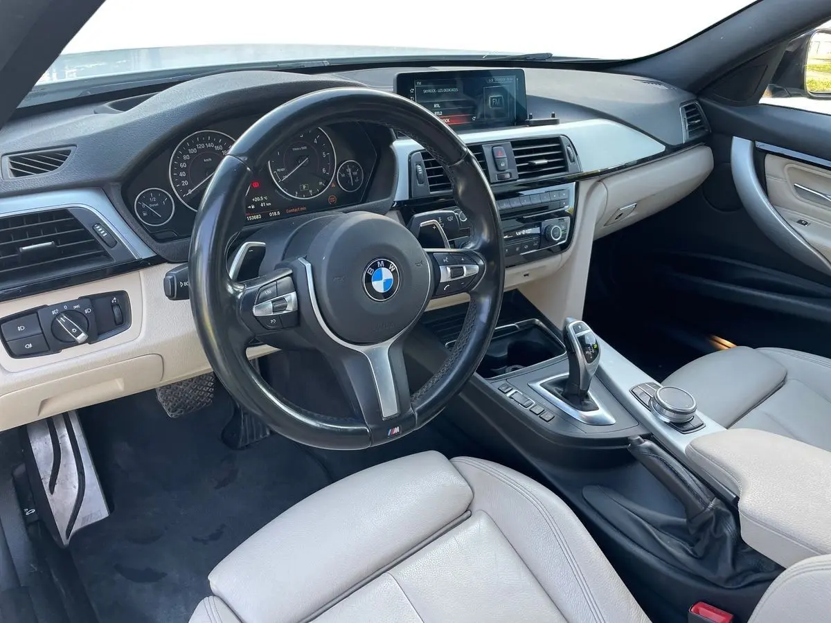 Intérieur clair de BMW Série 3 Touring F31 330DA XDrive 2017, vue côté conducteur sur tableau de bord et volant M Sport.