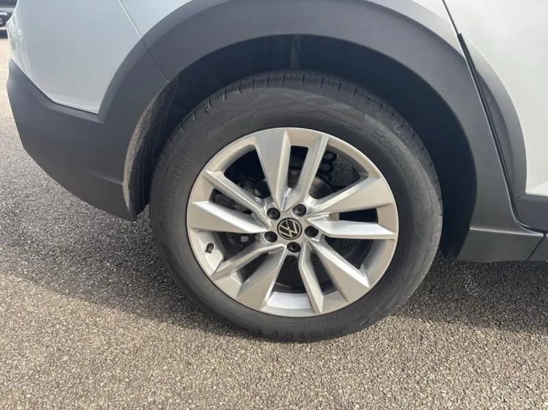 Gros plan sur la roue avant gauche avec jante alu du Volkswagen Taigo 2025 en Reflet d'Argent métallisé.