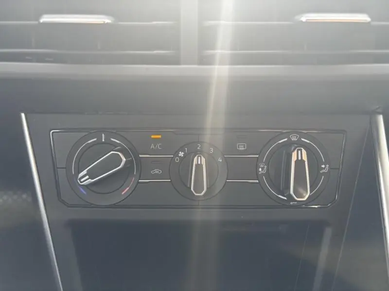 Panneau de commande de climatisation manuelle noir dans Volkswagen Taigo 2025, avec réglages de température et ventilation visibles.