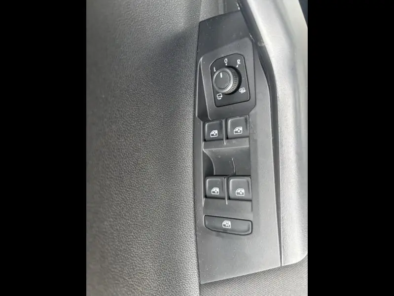 Panneau de commandes des vitres et rétroviseurs côté conducteur du Volkswagen Taigo 2025 en tissu noir.