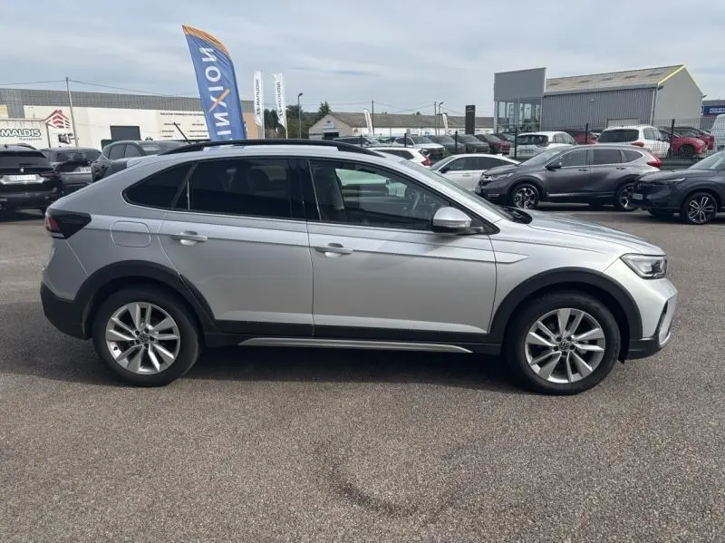 Profil droit d'un Volkswagen Taigo 1.0 TSI 116ch VW Edition 2025 en Reflet d'Argent métallisé, avec jantes alu et vitres teintées.