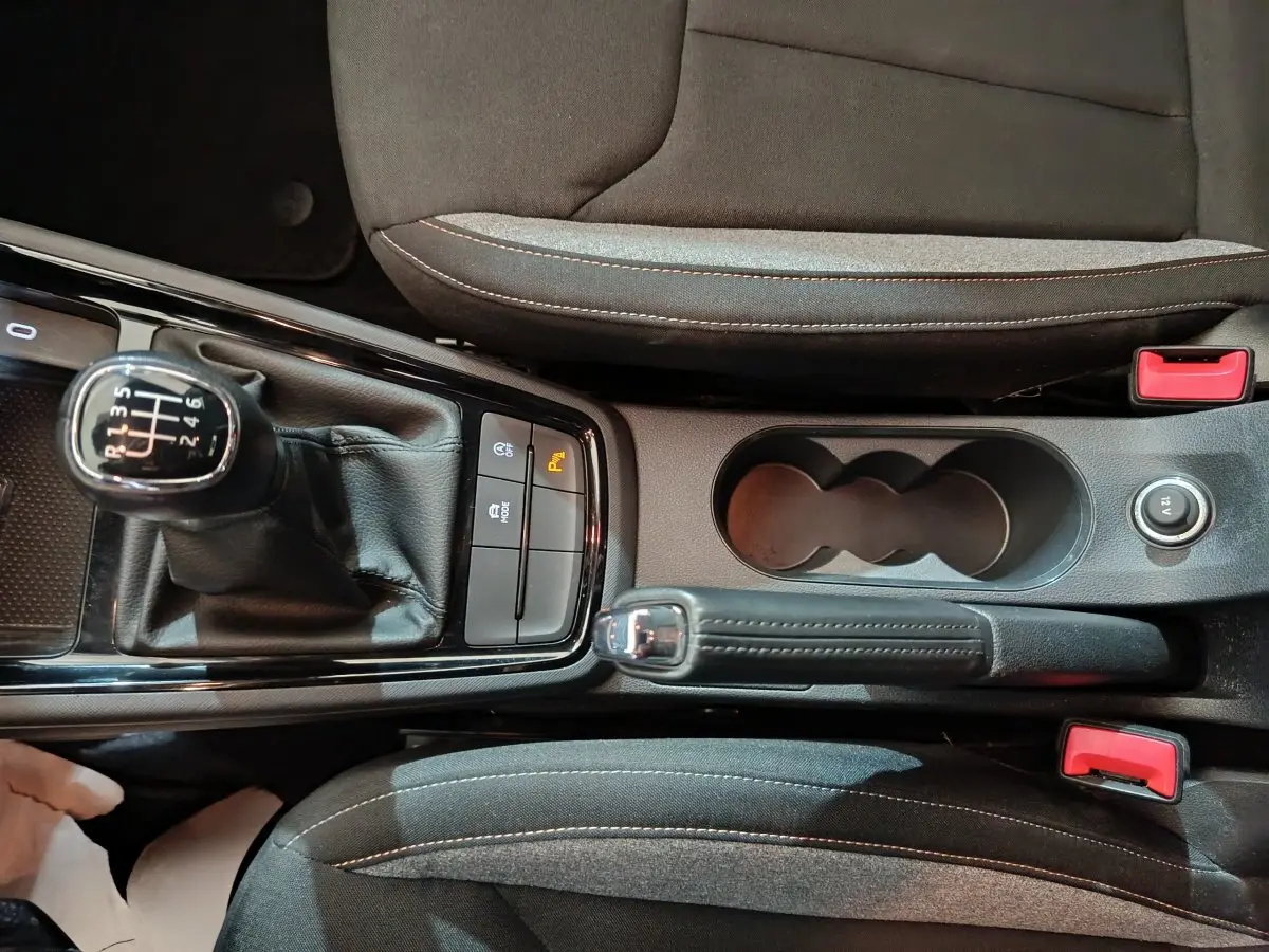 Vue plongeante sur la console centrale noire du Skoda Kamiq 2024 avec levier de vitesse manuel et frein à main cuir.