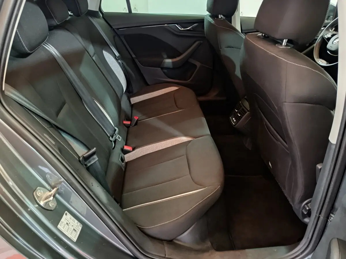 Vue intérieure côté gauche sur la banquette arrière noire avec inserts gris du Skoda Kamiq gris clair 2024.