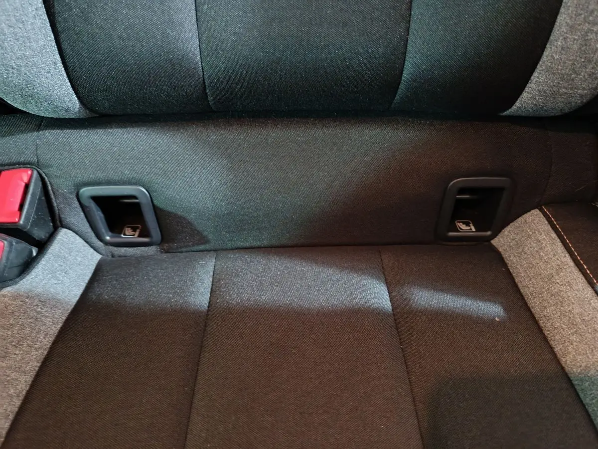 Gros plan sur la banquette arrière gris foncé du Skoda Kamiq 2024 avec fixation Isofix et ceintures rouges.