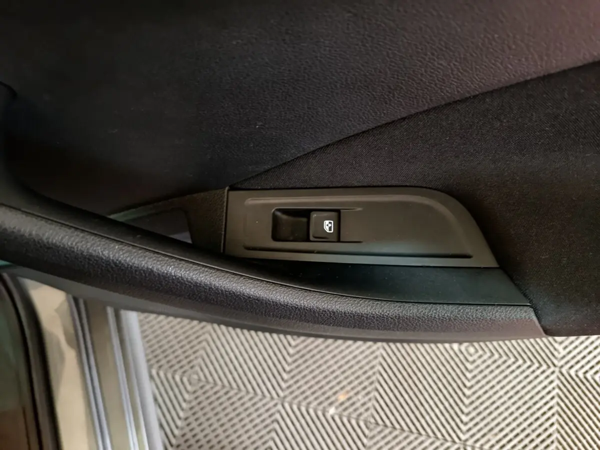 Gros plan sur le bouton de commande de lève-vitre côté conducteur du Skoda Kamiq gris clair 2024.