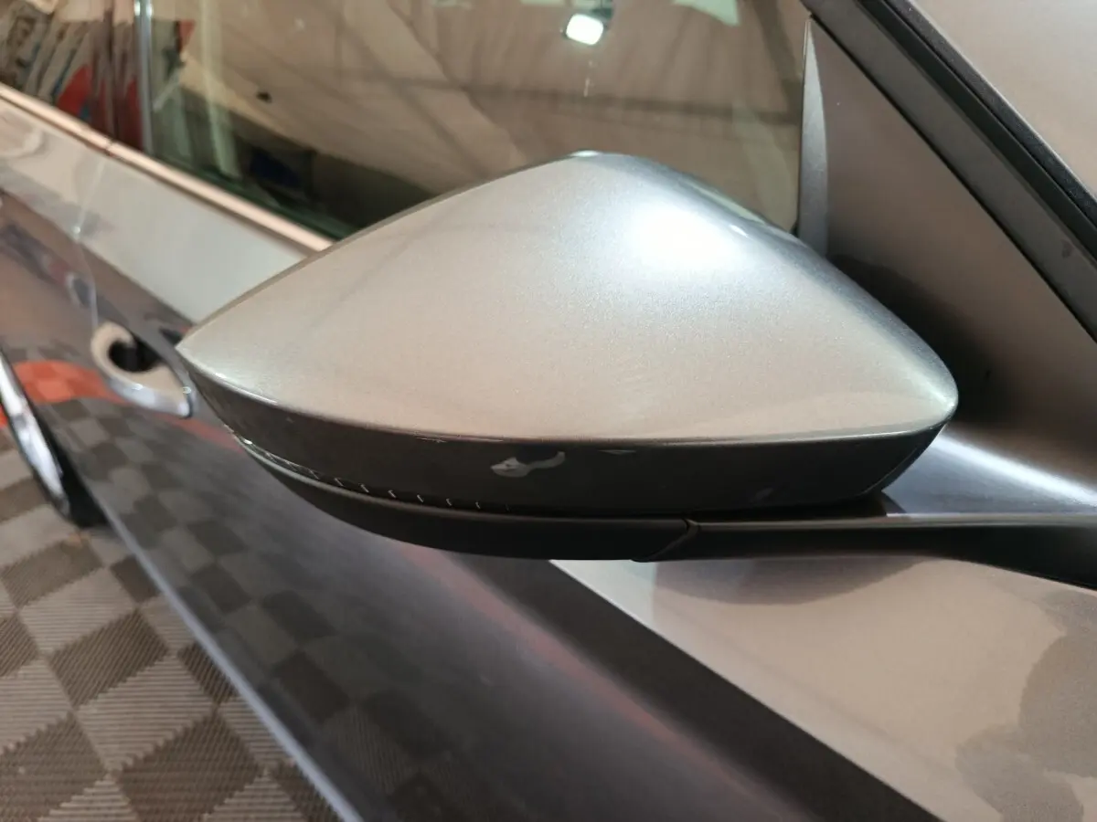 Rétroviseur côté conducteur gris clair du Skoda Kamiq 2024, vue rapprochée sur la portière et poignée.