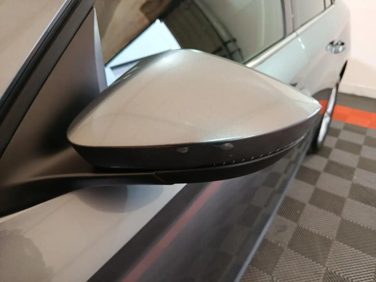 Rétroviseur côté gauche gris clair du Skoda Kamiq 2024, vue rapprochée avec carrosserie et roue arrière visibles.
