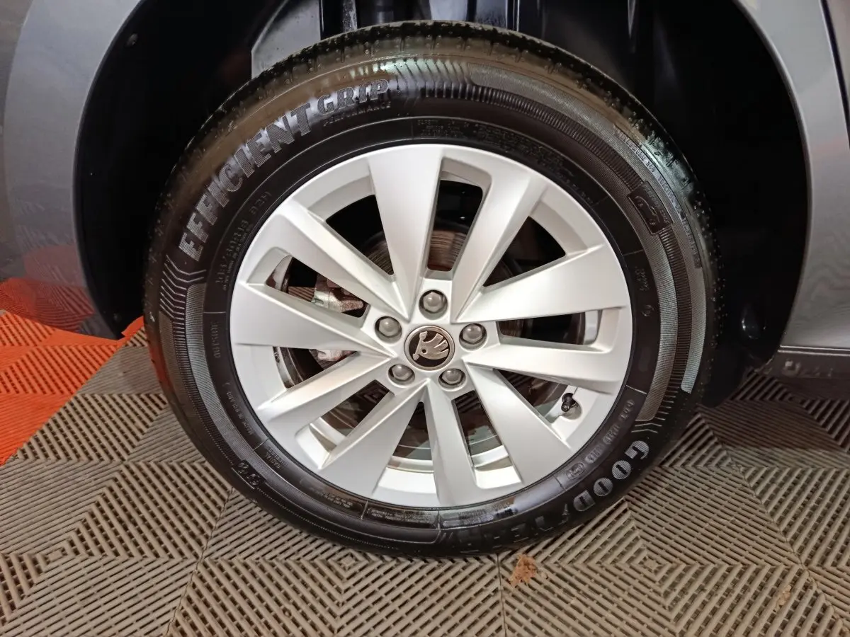 Gros plan sur la roue avant droite d’un Skoda Kamiq gris clair, avec jante alliage et pneu Goodyear.