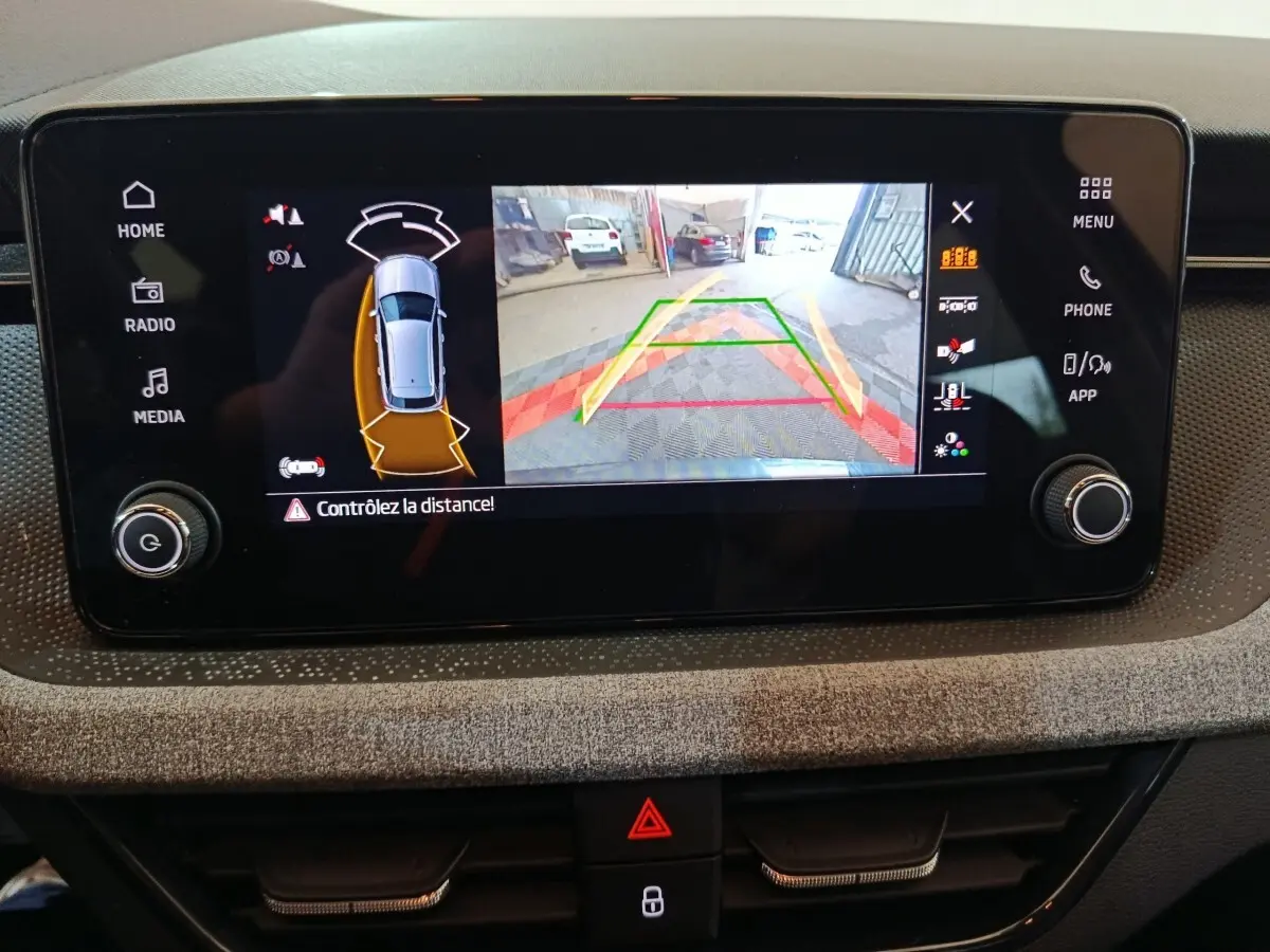 Écran tactile central du Skoda Kamiq gris clair montrant la caméra de recul avec guidage et alertes de distance.