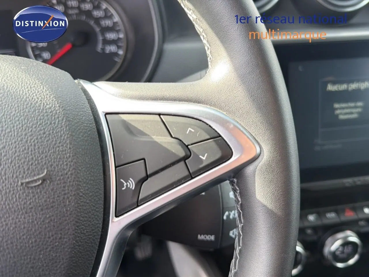 Gros plan sur les commandes au volant en cuir noir du Dacia Duster 2022, version ECO-G 100 Prestige.