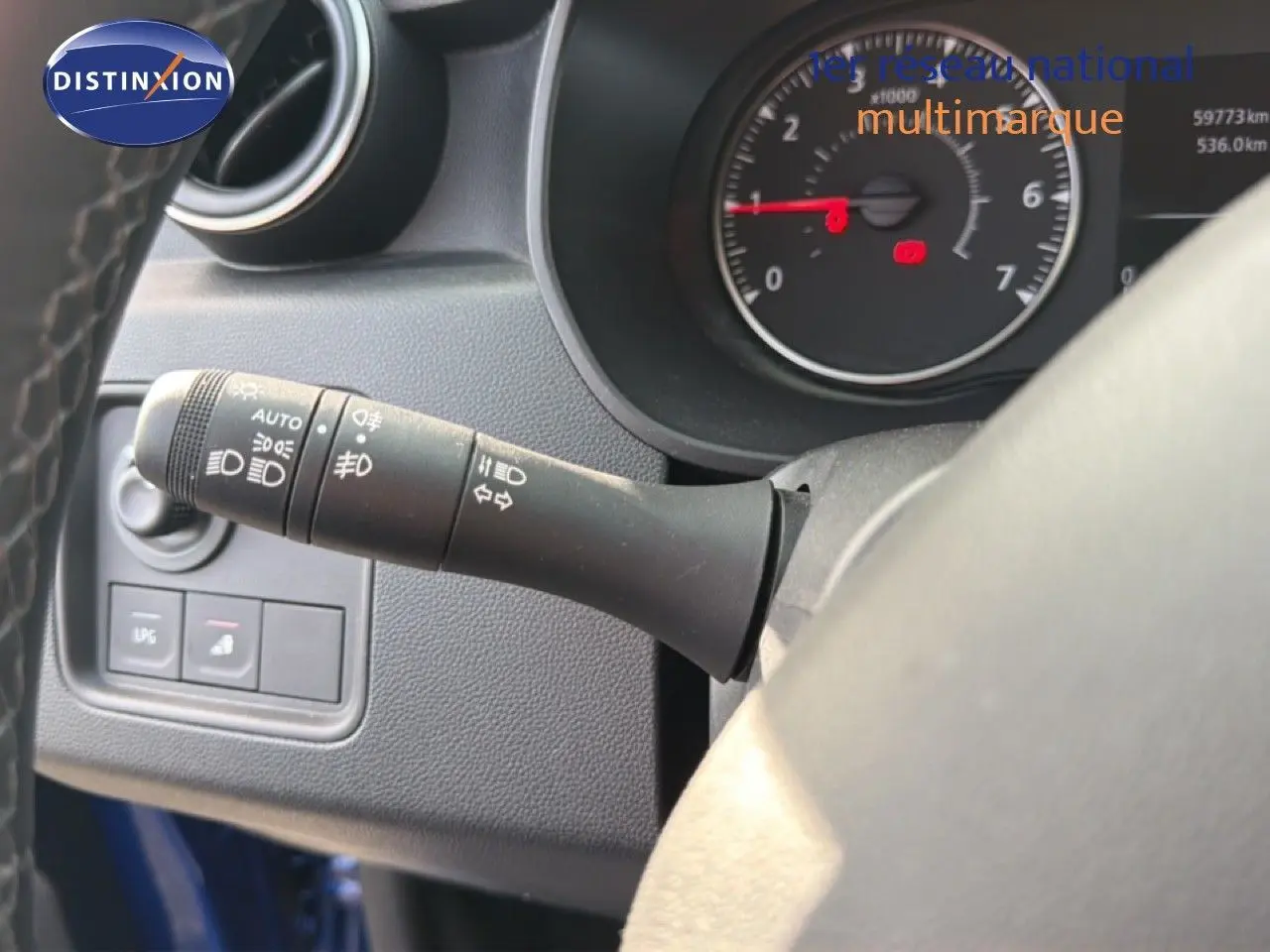 Gros plan sur la commande des phares et clignotants à gauche du volant du Dacia Duster bleu Iron 2022.