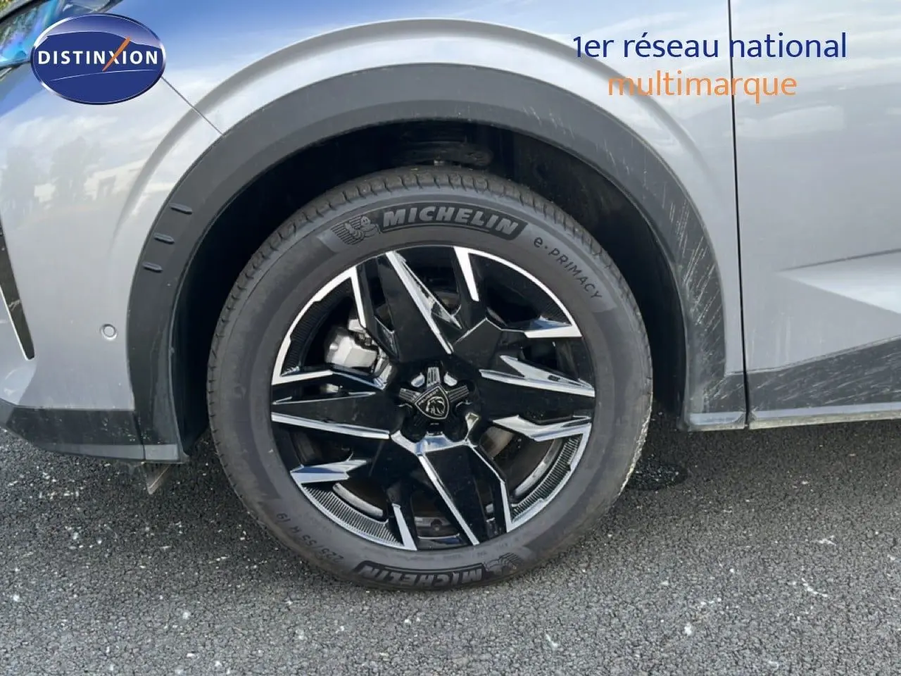 Gros plan sur la roue avant gauche du Peugeot 5008 gris Artense métal avec jante noire et détails chromés.