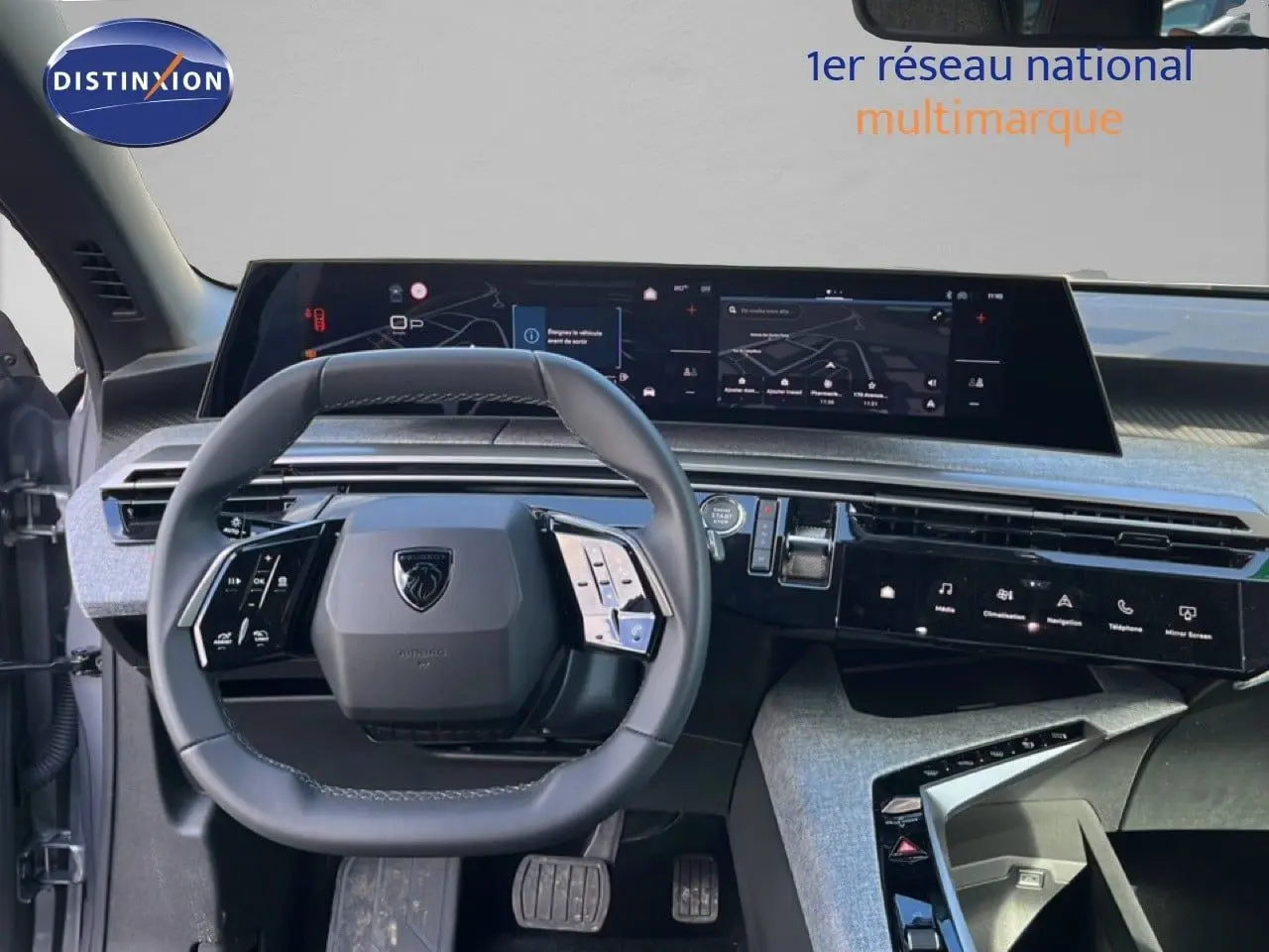Vue intérieure du tableau de bord et volant de la Peugeot 5008 gris Artense, avec écran tactile panoramique et commandes intégrées.