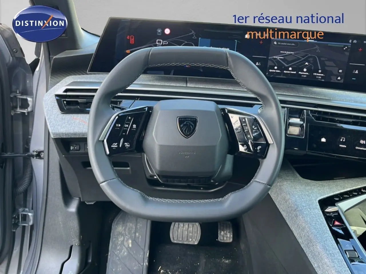 Vue intérieure centrée sur le volant multifonction gris noir du Peugeot 5008 1.2 Hybrid 145ch Allure, avec tableau de bord numérique.