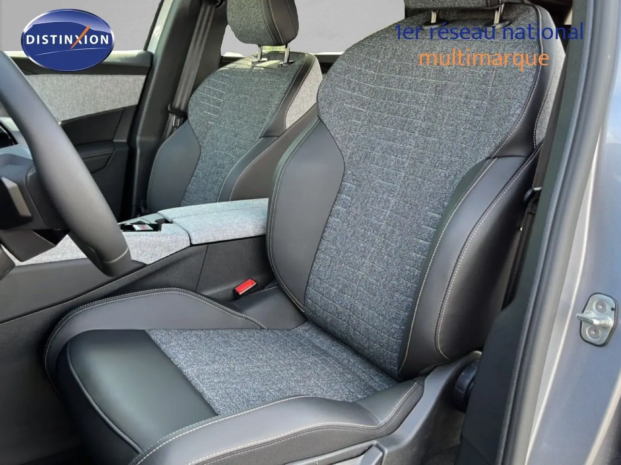 Vue intérieure côté conducteur du Peugeot 5008 2025 gris Artense, sièges tissu et cuir noir avec surpiqûres contrastées.