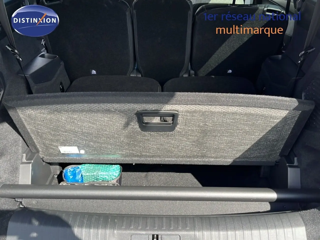 Vue arrière du coffre ouvert du Peugeot 5008 gris Artense Metal, montrant le compartiment de rangement sous plancher.