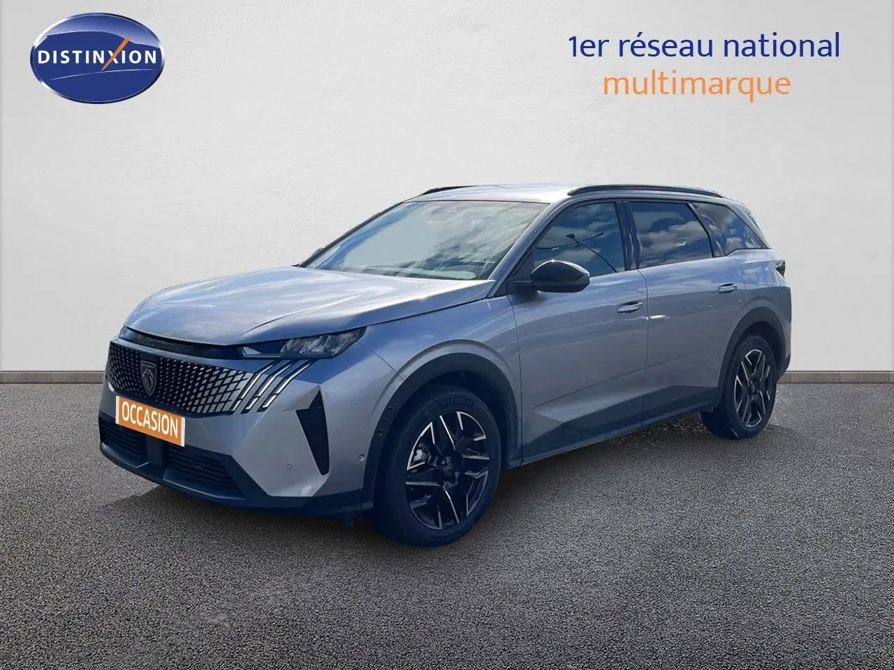 Peugeot 5008 gris Artense métal en 3/4 avant droit, avec jantes noires et calandre distinctive moderne.