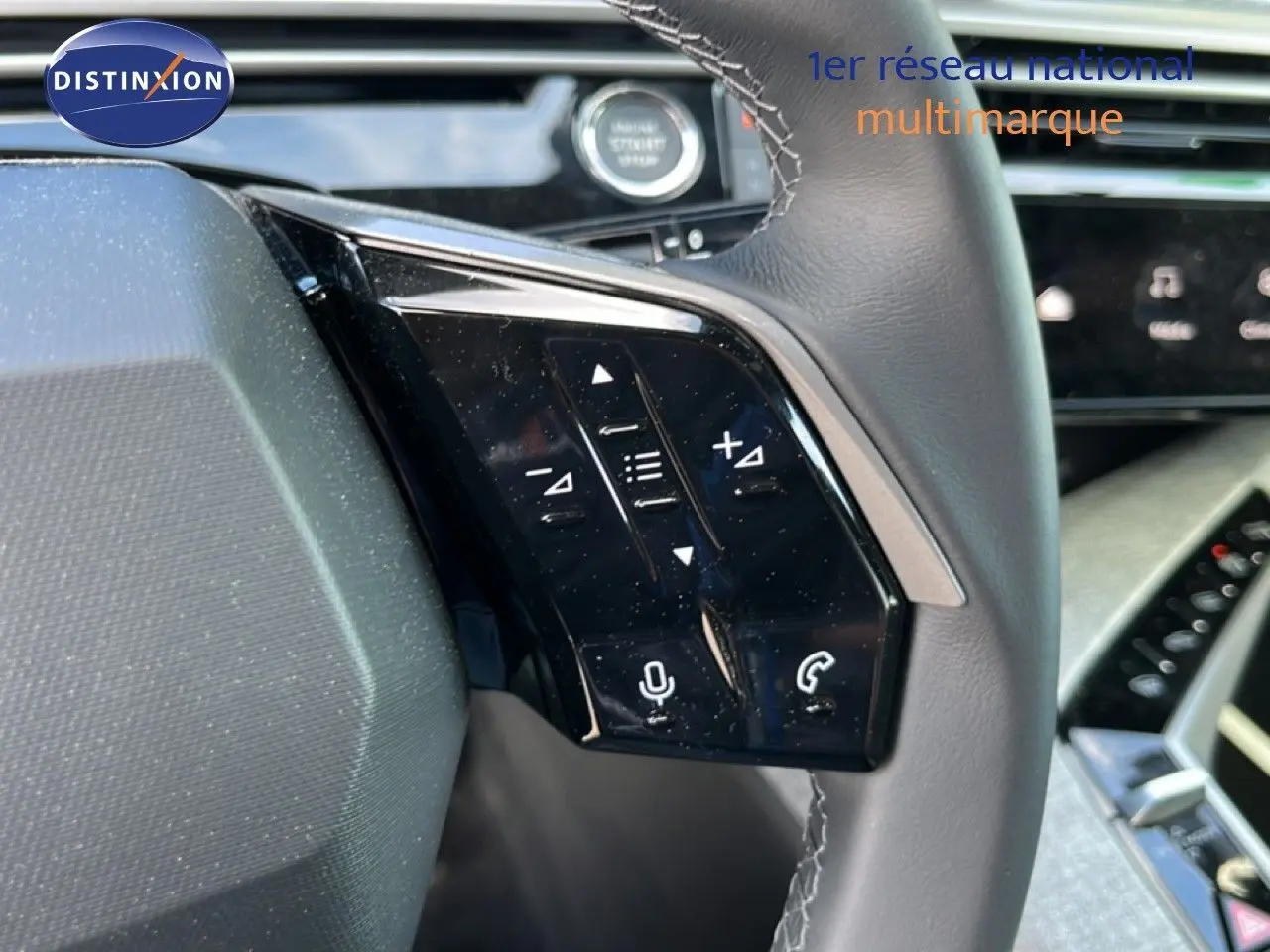 Détail du volant côté gauche du Peugeot 5008 gris Artense, avec commandes audio et téléphone intégrées.