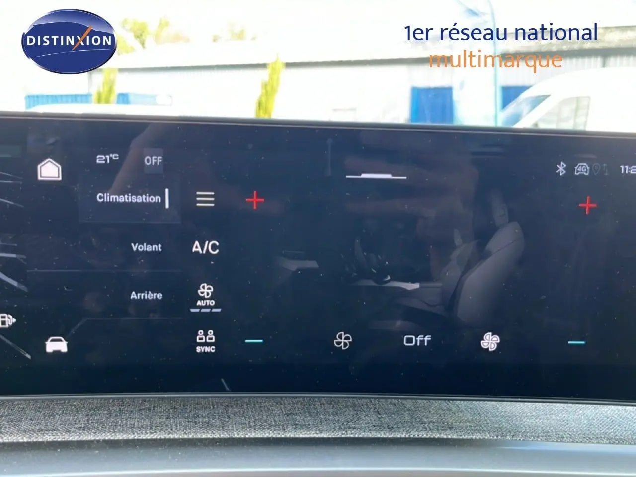 Écran tactile intérieur du Peugeot 5008 2025 affichant les réglages de climatisation, avec reflet des sièges noirs.