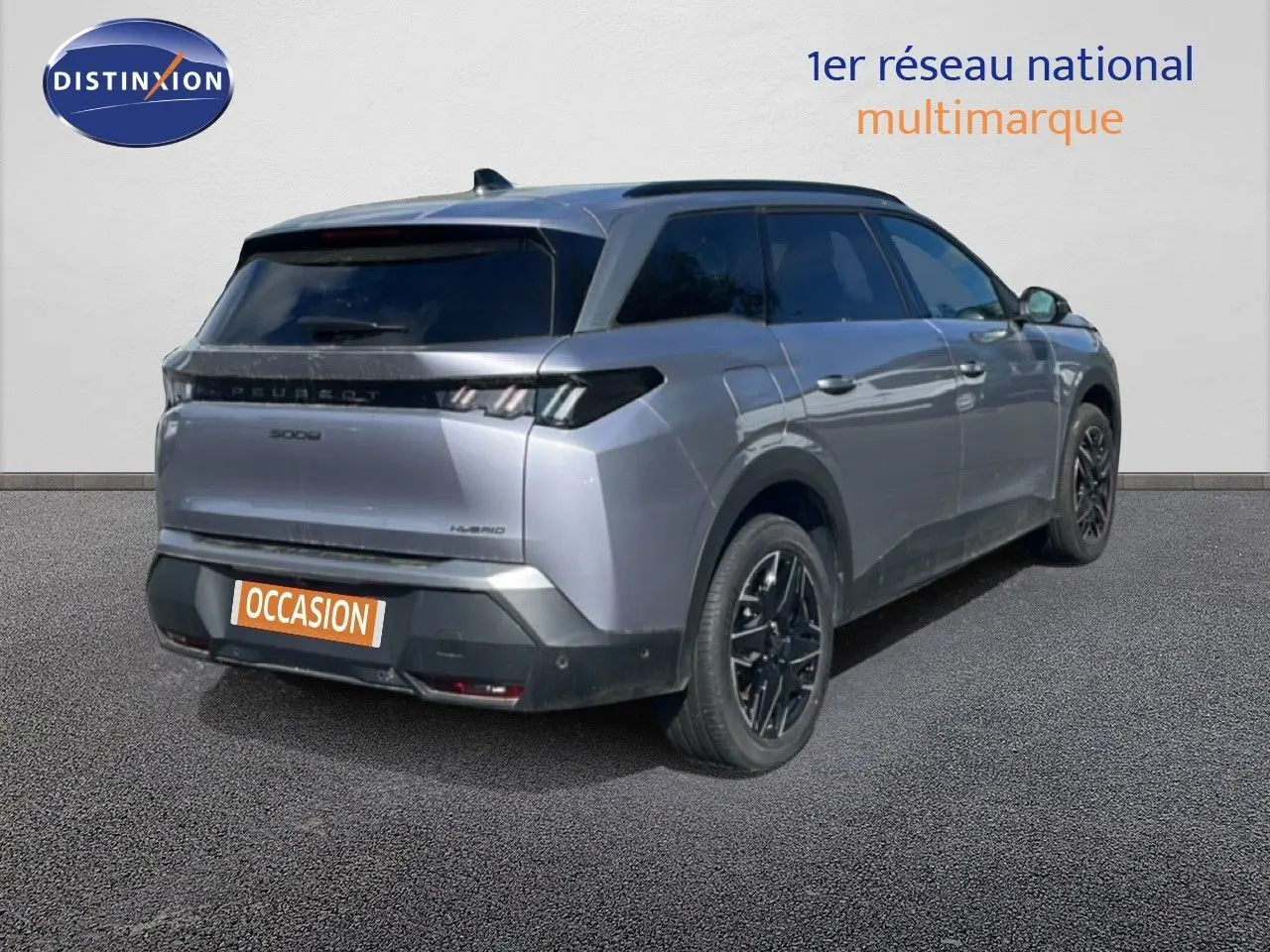 Vue 3/4 arrière droite d’un Peugeot 5008 gris Artense métallisé avec jantes noires et vitres teintées.