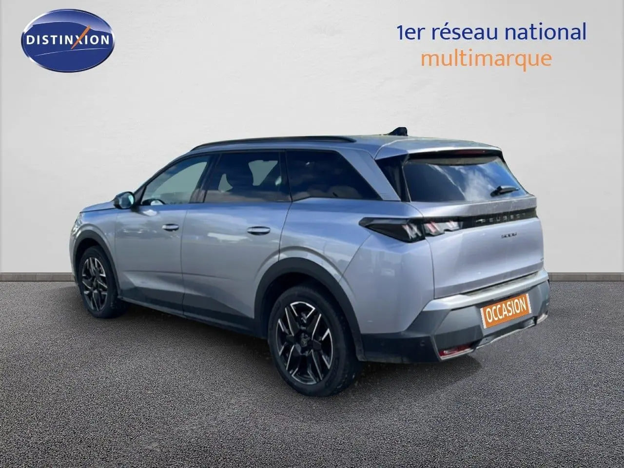 Peugeot 5008 gris Artense métal, vue 3/4 arrière droit, jantes noires et toit panoramique visible.