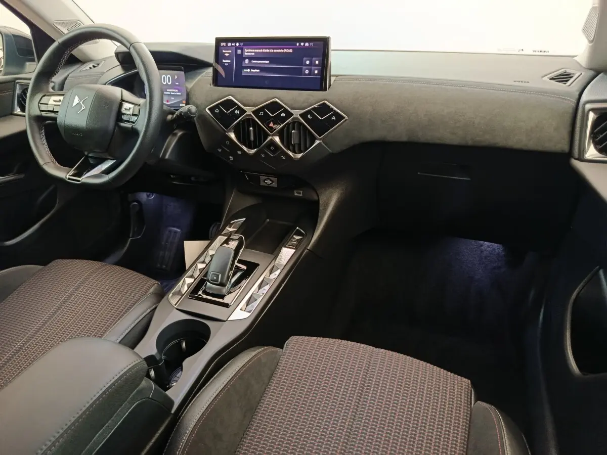 Vue intérieure côté conducteur du tableau de bord et console centrale du DS3 1.2 PureTech 130 gris foncé avec écran tactile et volant cuir multifonctions.