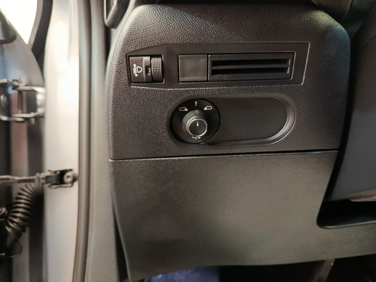 Détail du panneau de réglage des phares et ventilation côté gauche intérieur d'une DS3 1.2 PureTech 130 gris foncé 2024.